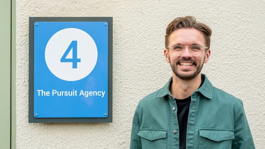 Rob outside TPA sign-2 Rob Curtis, founder of The Pursuit Agency, celebrating the company's fourth anniversary